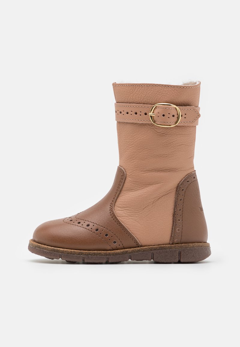 Bottines en cuir marron avec un dessus en cuir clair contrastant, des perforations décoratives, une sangle à boucle et une semelle en caoutchouc texturée.