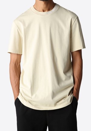 Hellbeiges Baumwoll-T-Shirt mit Rundhalsausschnitt und kurzen Ärmeln. "THE NORTH FACE" Logo in Weiß am Kragen. Lockere Passform und glatte Textur.