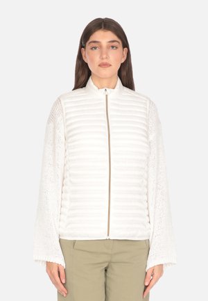 Giacca bianca trapuntata con colletto alto e chiusura con zip, caratterizzata da maniche in maglia testurizzata. Materiale liscio con un design leggero.