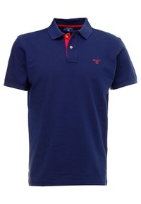 Mörkblå polo skjorta i bomull, med en röd innerkrage och en liten röd logotyp på vänstra bröstet. Kort ärm, klassisk passform.