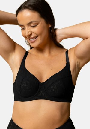 Soutien-gorge noir présentant un design texturé géométrique, avec soutien-gorge à armatures et bretelles ajustables. Tissu lisse avec une silhouette classique.