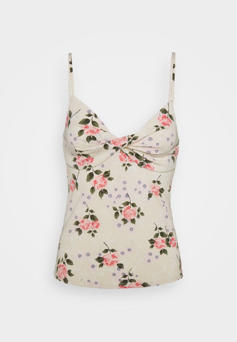 Camisole florale à fines bretelles avec un fond crème, des roses roses et des accents violets. Texture douce et design avant torsadé.