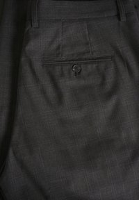 Pantalones de cuadros grises con una textura suave, corte slim, y un bolsillo trasero realzado por un solo botón negro.