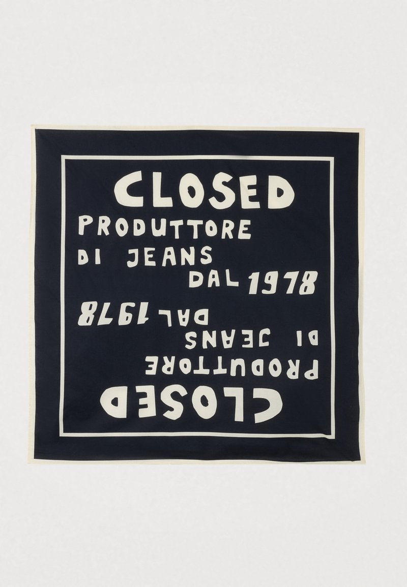 Τετράγωνο ύφασμα σκούρου μπλε χρώματος με λευκό περίγραμμα και έντονο λευκό κείμενο που αναγράφει «CLOSED PRODUTTORE DI JEANS DAL 1978» με καθρεφτισμένη, ανεστραμμένη επανάληψη.