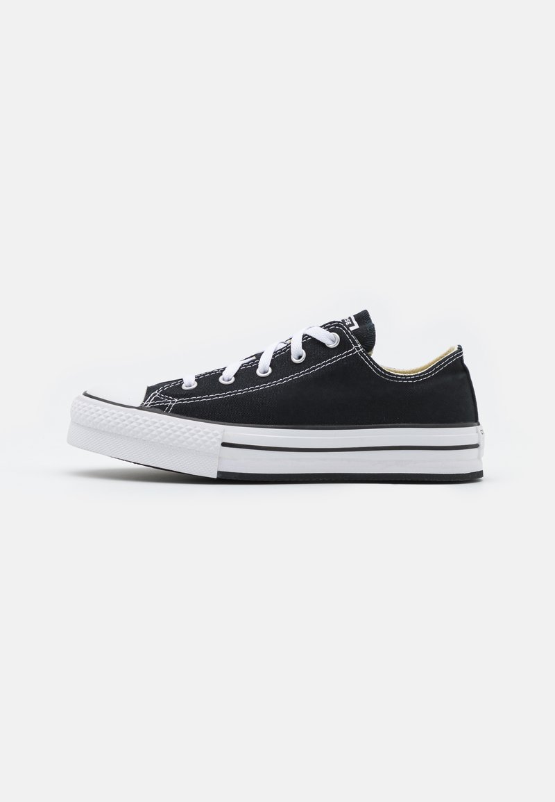 Schwarze Leinensneaker mit weißer Gummisohle, schwarz-weißen Schnürsenkeln und einem schmalen Profil. Verfügt über gestickte Akzente und minimalistisches Branding.