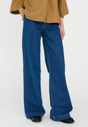 Weit geschnittene blaue Jeans aus Denim mit hoher Taille und sauberem Abschluss. Der Stoff hat eine glatte Textur mit minimalen Details und ohne sichtbare Taschen.