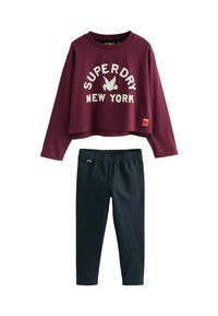 Felpa corta bordeaux con stampa "Superdry New York" in bianco, abbinata a leggings blu navy scuro, con vita elastica e tessuto liscio.