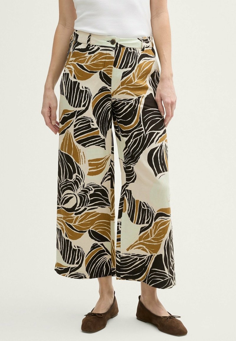 Pantalons larges en tissu crème avec un motif floral audacieux en noir, marron et rouille. Finition avec une fermeture à bouton.