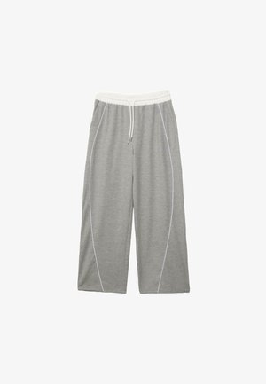 Pantaloni della tuta grigi a gamba larga con vita elastica bianca, coulisse bianca e cuciture laterali curve bianche, distesi su uno sfondo bianco.