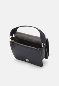 Laukkua navy-väristä nahkaa, jossa on tekstuuripinta, näkyvä kulta vetoketju ja kuvioitu kangasnauha. Kompakti malli, jossa on etutasku.