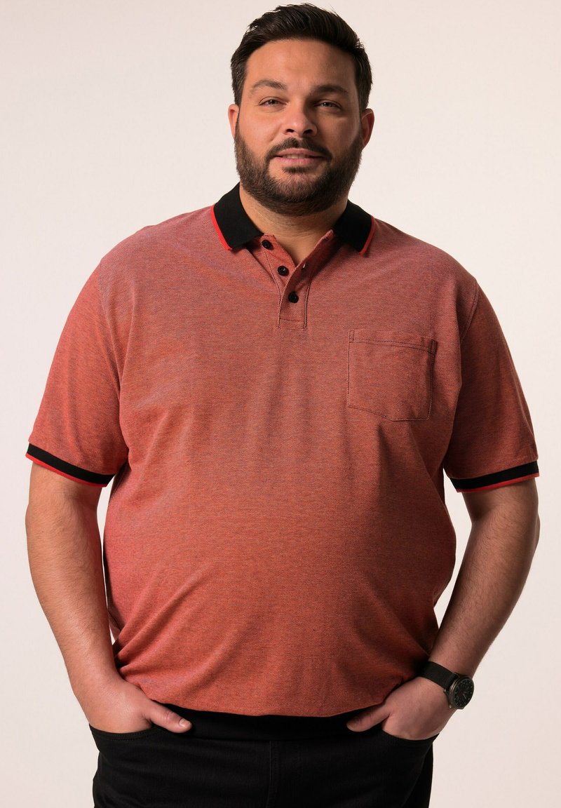 Lyhythihainen polo-paita punaisena, jossa on teksturoitu pinta, musta kaulus, punaiset yksityiskohdat ja rintatasku. Sopii rentoon pukeutumiseen.