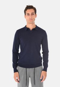Maglione pullover blu navy con colletto, polsini e orlo a costine. Realizzato in un tessuto liscio, presenta uno stile aderente.