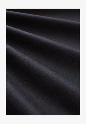 Zwarte stof met een gladde textuur, met geplooide lagen die zachte golven creëren en de zachte, matte oppervlakte benadrukken.