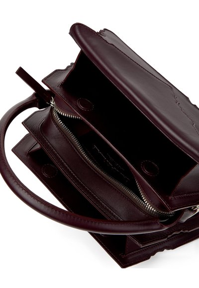 Sac à main en cuir bordeaux foncé avec poignée supérieure, rabat ouvert et compartiment intérieur zippé.