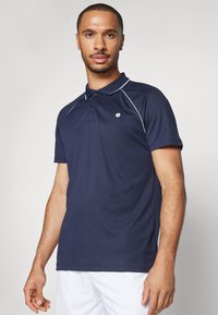 Námornícky polo s príslušenstvom v bielej farbe. Obsahuje golier, zapínanie na tri gombíky a malé logo na hrudi. Vyrobené z hladkej tkaniny.