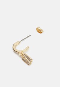 Brinco de argola dourada com superfície texturizada, apresentando um encanto retangular pendurado decorado com strass claros. Inclui fecho tipo botão.