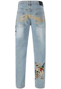 Lichtblauwe spijkerbroeken kenmerken zich door het gouden "Ed Hardy"-logo, een geborduurd schedelontwerp met de frase "DEATH BEFORE FASHION" en levendige accenten.