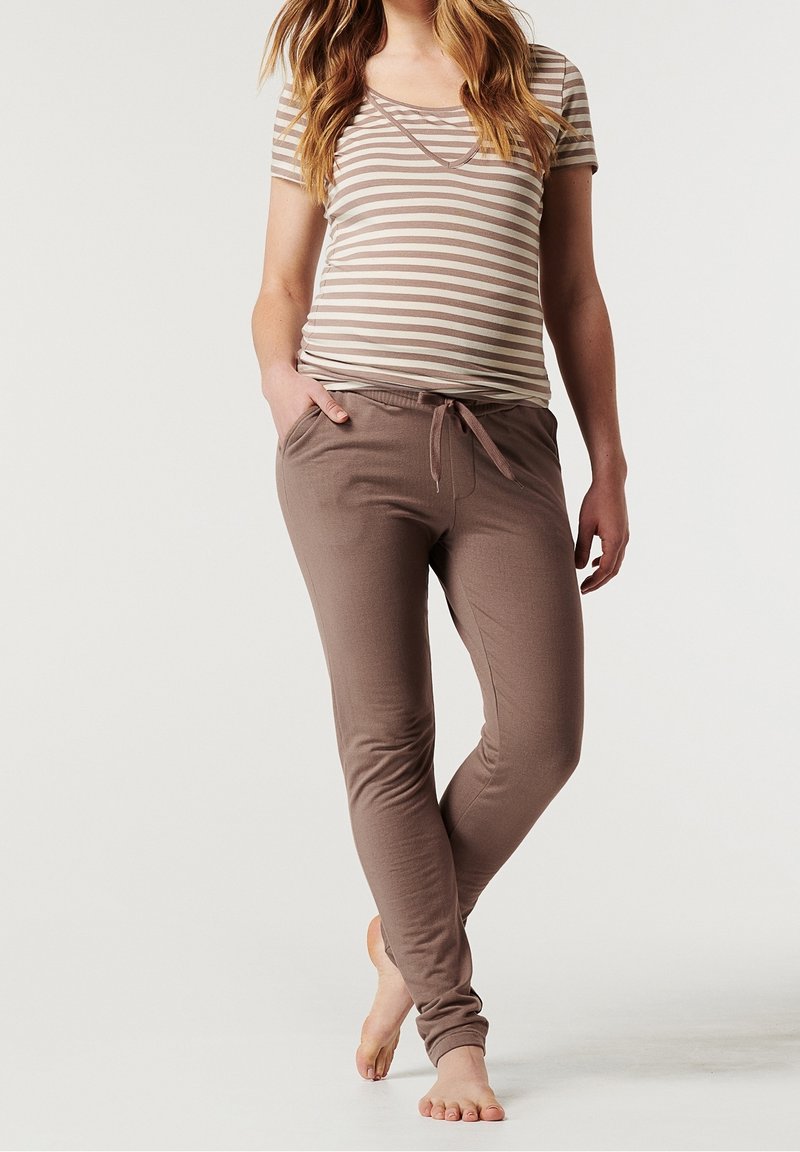 Top de maternidad a rayas en beige y crema, combinado con joggers suaves en marrón con cordón y ajuste slim que cuentan con bolsillos laterales.