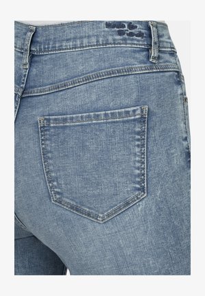 Hellblaue Jeans aus Denim mit einer Gesäßtasche im typischen geraden Design und sichtbaren Nähdetails. Die Textur wirkt leicht ausgewaschen.