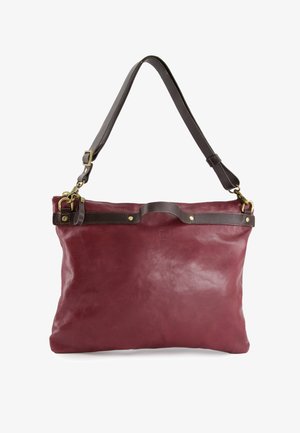 Læder tote taske i dyb burgunder med glat tekstur, brun læderrem, guldfarvede hardware detaljer og lynlåslukning.