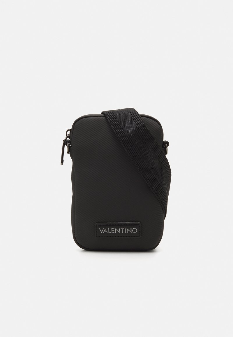 Borsa a tracolla nera in nylon con finitura textured, chiusura con zip e tracolla con il logo. Forma rettangolare con patch del logo.
