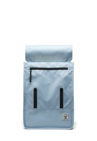 Sac à dos bleu à rabat fabriqué en tissu durable ; comporte une poche zippée noire, des bretelles noires et un écusson logo en bas.