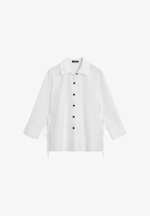 White button-up shirt with a collar, featuring black buttons down the front and ties on the sides. Lightweight fabric, long sleeves.