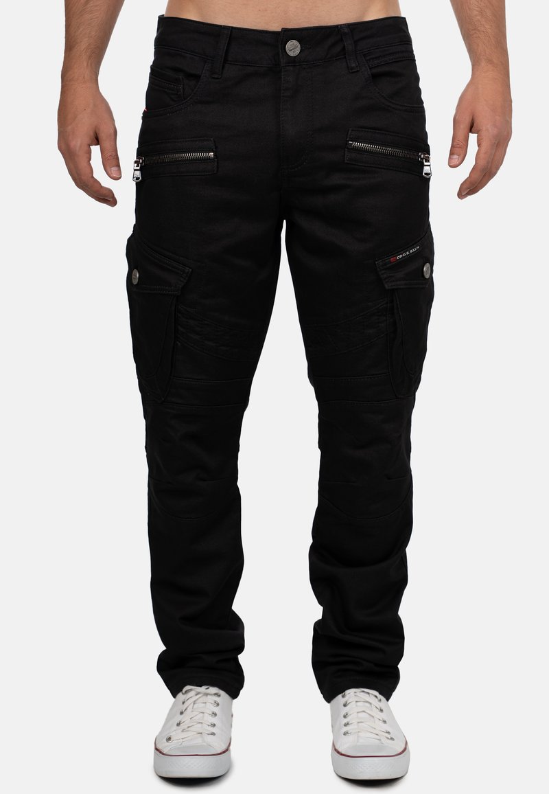 Pantaloni cargo neri realizzati in un tessuto robusto, con numerose tasche con zip e bottoni, un design aderente e orli a costine.