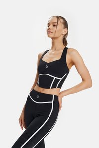 Black athletic crop top with white accents and a square neckline, paired with black leggings featuring white side panels and logo detail.