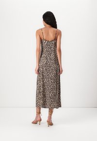 Rochie maxi cu imprimeu leopard, cu bretele subțiri ajustabile și o siluetă fluidă. Materialul pare ușor și are o textură moale.