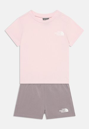 Light pink short-sleeve T-shirt with gray shorts, both with white The North Face logos, designed for children.
