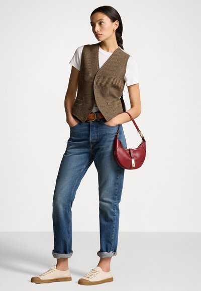 Gilet à carreaux marron sur un t-shirt blanc, accompagné de jeans en denim bleus. Les accessoires incluent un sac bordeaux et des baskets beiges.