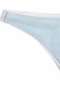 Deux sous-vêtements bikini en coton pliés, l'un bleu clair avec un motif texturé superposé à une paire blanche unie.