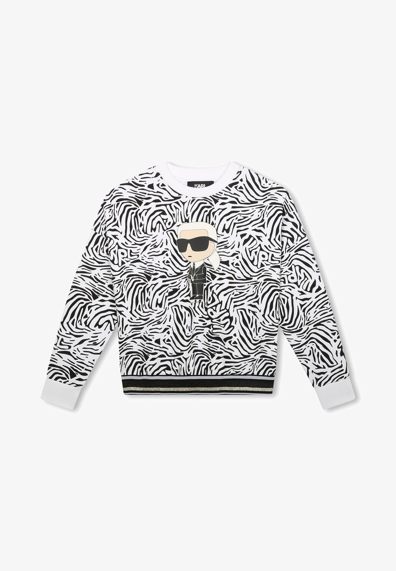 Sweatshirt noir et blanc à motif zèbre avec une figure de dessin animé portant des lunettes de soleil, agrémenté d'un ourlet à rayures contrastantes noir et or.