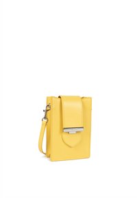 Sac en cuir jaune à bandoulière avec une fermeture à rabat, accent en métal argenté et une sangle détachable. Forme rectangulaire avec des bords cousus.