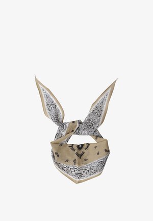 Beżowo-biała bandana z czarnymi wzorami paisley, zawiązana na supeł z dwoma ostro zakończonymi końcami stojącymi pionowo.