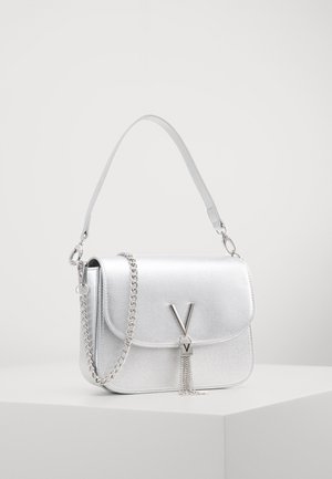 Bolso de mano metálico plateado con un acabado texturizado, cierre de solapa y cadena como asa. Presenta un destacado logo en forma de "V" y un detalle decorativo de borlas.