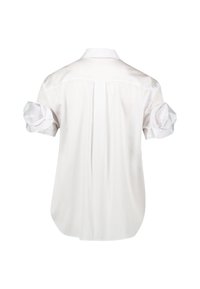 Camicia bianca a maniche corte con risvolti, dotata di un dettaglio sulla spalla posteriore e un orlo leggermente curvato. Realizzata in tessuto morbido e leggero.