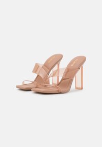 Naakte open teen hoge hak sandalen met transparante banden; vierkante, heldere blokhak; glad materiaal met een minimalistisch ontwerp.