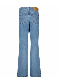 Ljusblå utsvängda jeans i denim. Har två bakfickor med böjda sömmar och en brun läderlapp vid midjan.