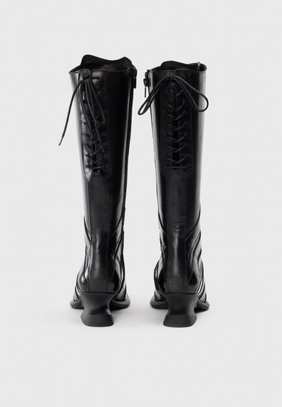 Black knee-high boots with a glossy leather finish, lace-up front, and zip closure. Curved heel and textured side detailing.