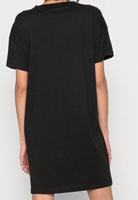 Svart oversized t-shirt klänning i mjuk bomull jersey. Korta ärmar och rundad halsringning. Sömlös design med en avslappnad passform.