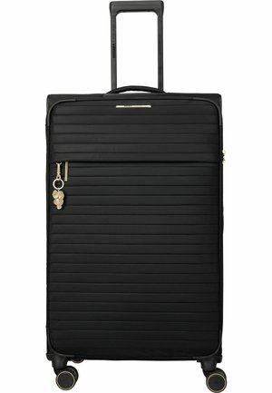 Maleta rígida negra con estrías horizontales, cuatro ruedas giratorias, asa retráctil, bolsillo frontal con cremallera y charm en forma de hoja dorada en el tirador de la cremallera.