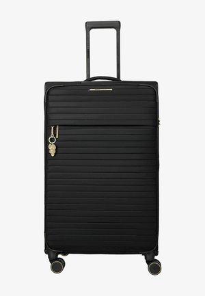 Valise rigide noire avec rainures horizontales, quatre roues pivotantes, poignée rétractable, poche avant zippée et breloque feuille dorée sur la tirette du zip.