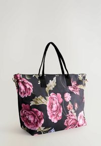 Must have must tote kott, millel on suur roosa lillemuster, mustast kangast käepidemetega ja lukuga sulgemine. Vastupidav materjal, millel on sile tekstuur.