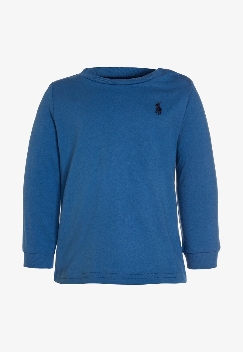 Modrá dlouhá rukávová košile vyrobená z bavlny s kulatým výstřihem. Obsahuje malé, tmavé logo na hrudi a ribbované manžety.