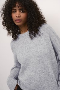 Lichtgrijze gebreide trui met lange mouwen, ronde hals en zachte textuur. Het model toont het kledingstuk in een lichte hoek.
