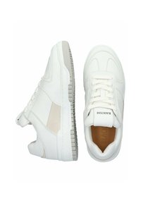 Pari valkoisia matalavartisia tennareita, joissa on nauhat, beige sivupaneeli ja "BLACKSTONE"-teksti kielen päällä, esitetty ylhäältä ja sivulta.