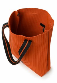 Borsa a spalla arancione a righe con manici neri e una larga apertura superiore. L'interno è texture e presenta una piccola etichetta nera sul lato.