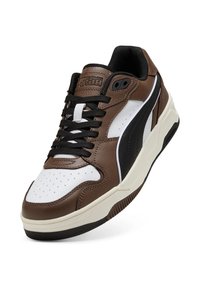 Braune Ledersneaker mit weißen und schwarzen Akzenten, perforierter Zehenbereich, schwarzen Schnürsenkeln und gepolstertem Kragen. Mit einer dicken Gummisohle ausgestattet.